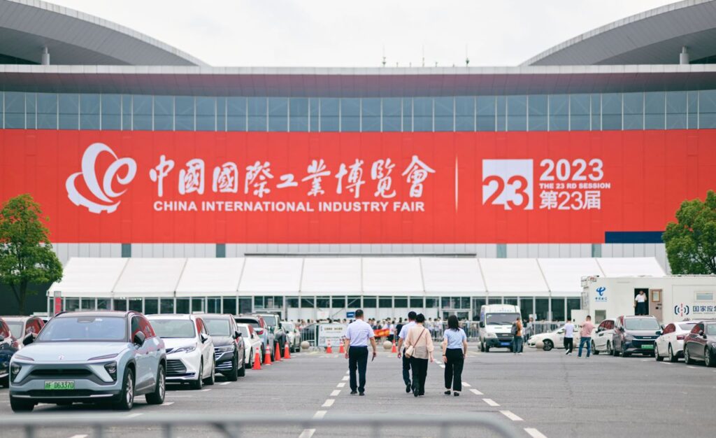 Entrance to China International Industry Fair 2023 in Shanghai, featuring people and cars.